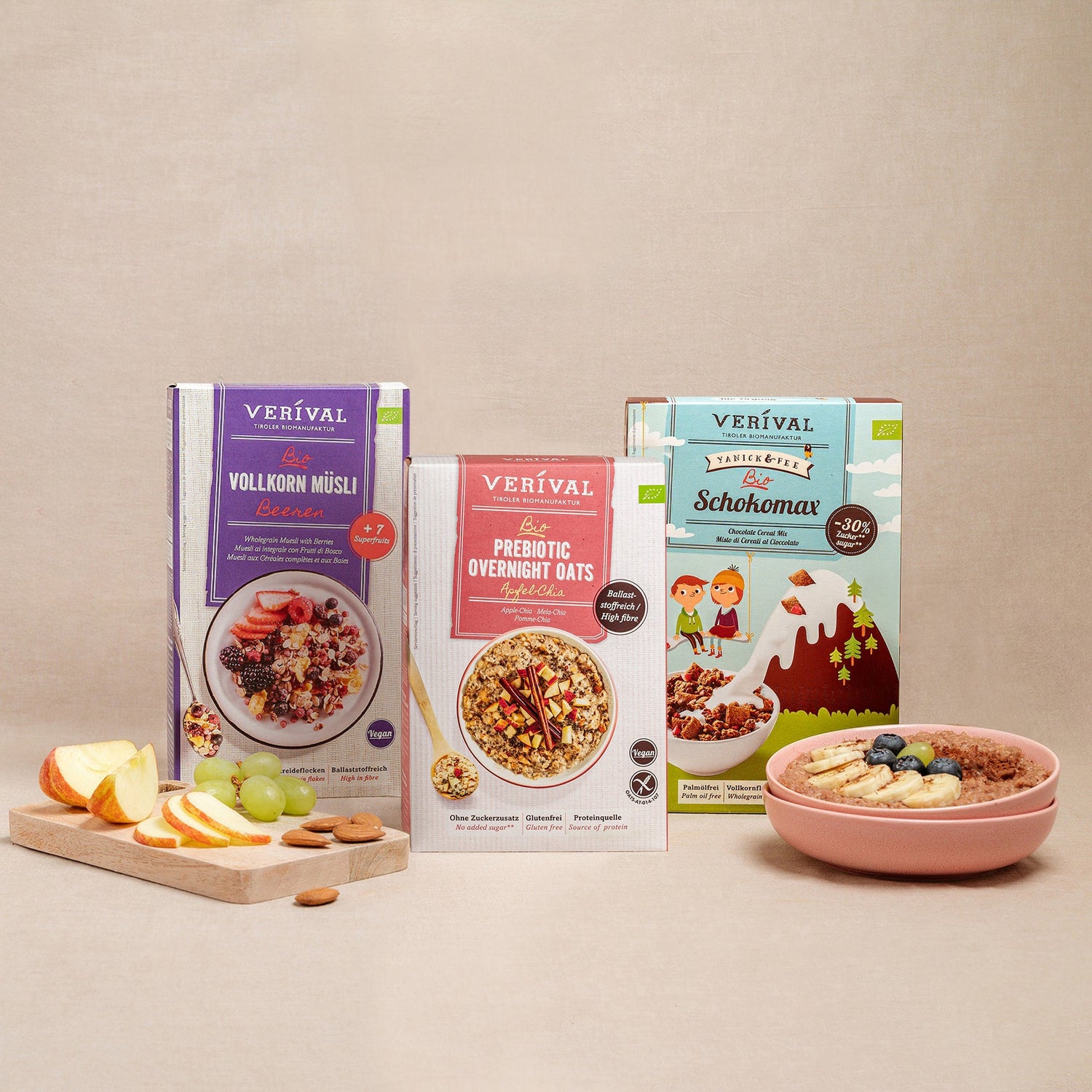 Drei Verival-Müslipackungen werden ausgestellt, darunter Vollkorn Müsli, Prebiotic Overnight Oats und Schokomax. Davor stehen eine Schüssel Müsli und geschnittenes Obst auf einem Schneidebrett.
